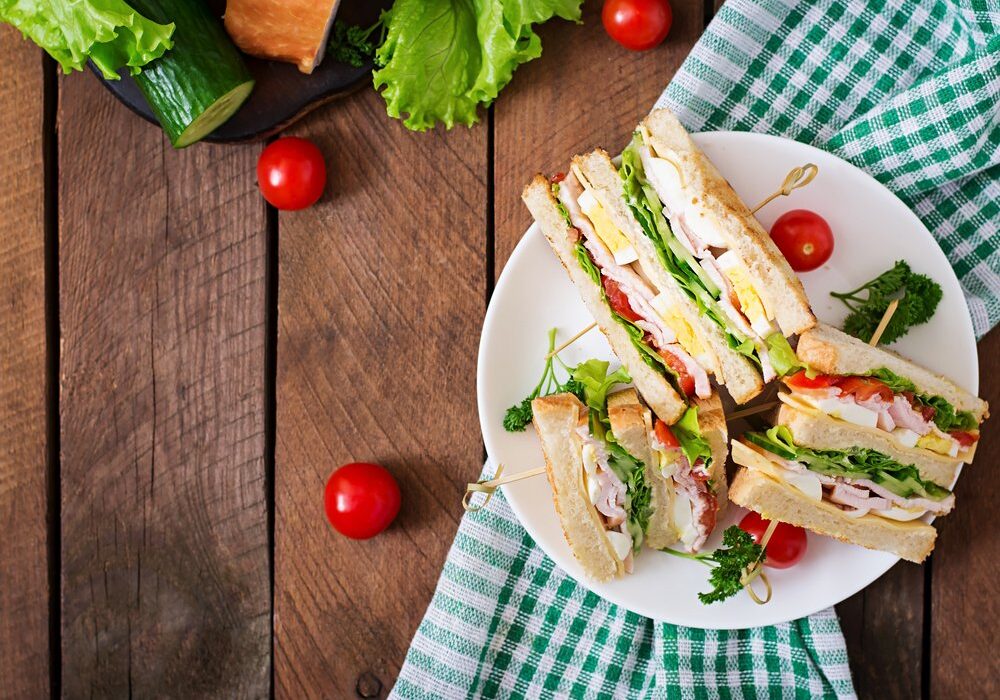Club,Sandwich,With,Cheese,,Cucumber,,Tomato,,Ham,And,Eggs.,Top